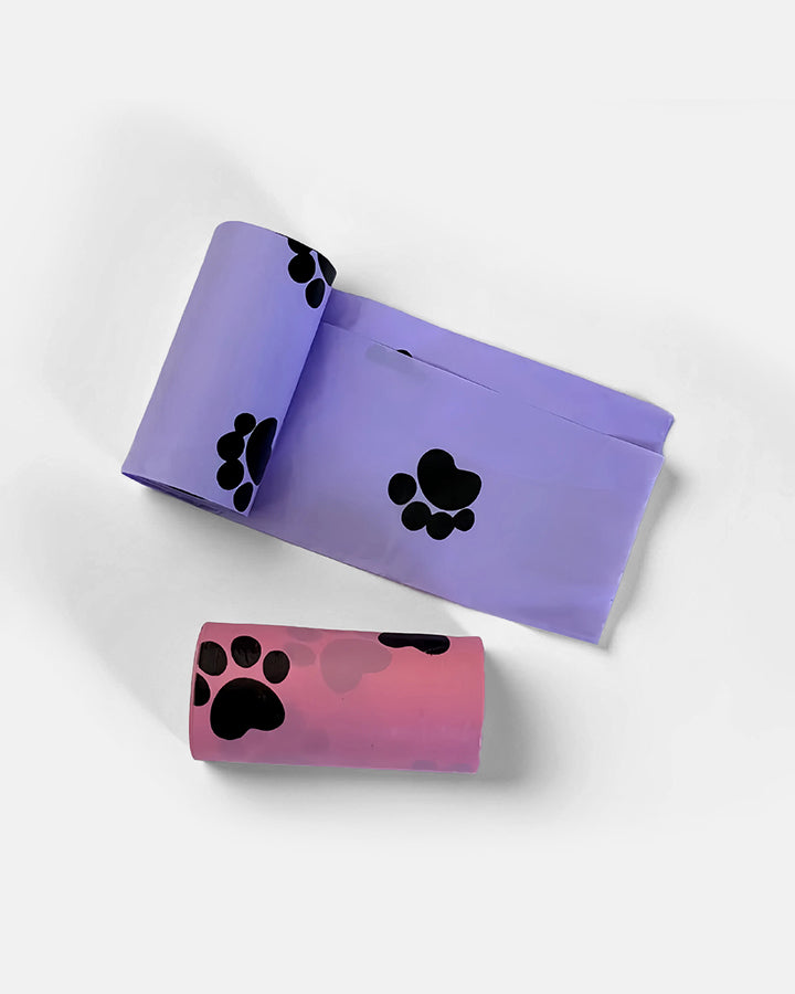 Detail view of biodegradable dog poop bags in purple and pink, showcasing the paw print design.