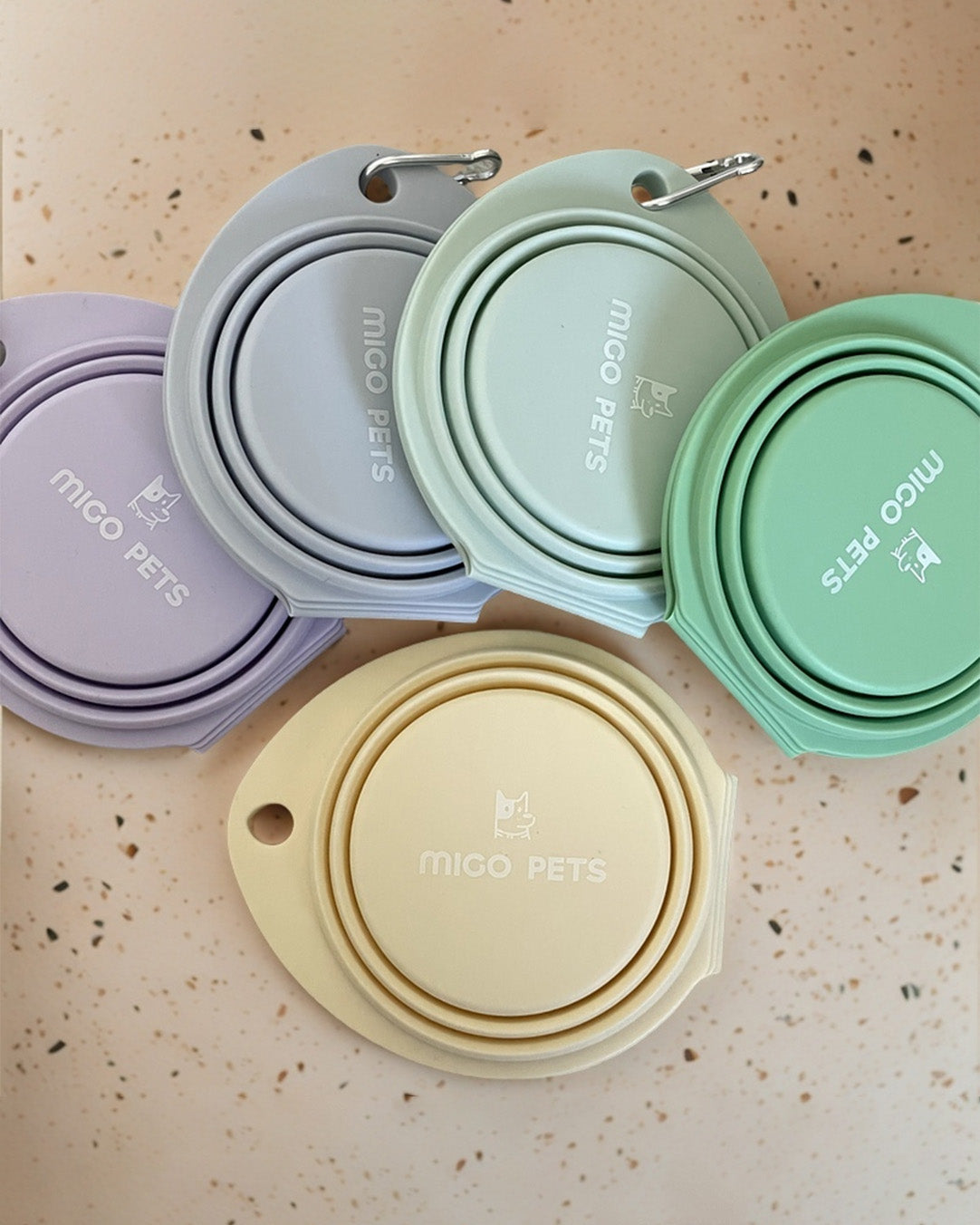 A top view of MIGO Pets collapsible travel double dog bowls in pastel colors, showcasing their compact design.