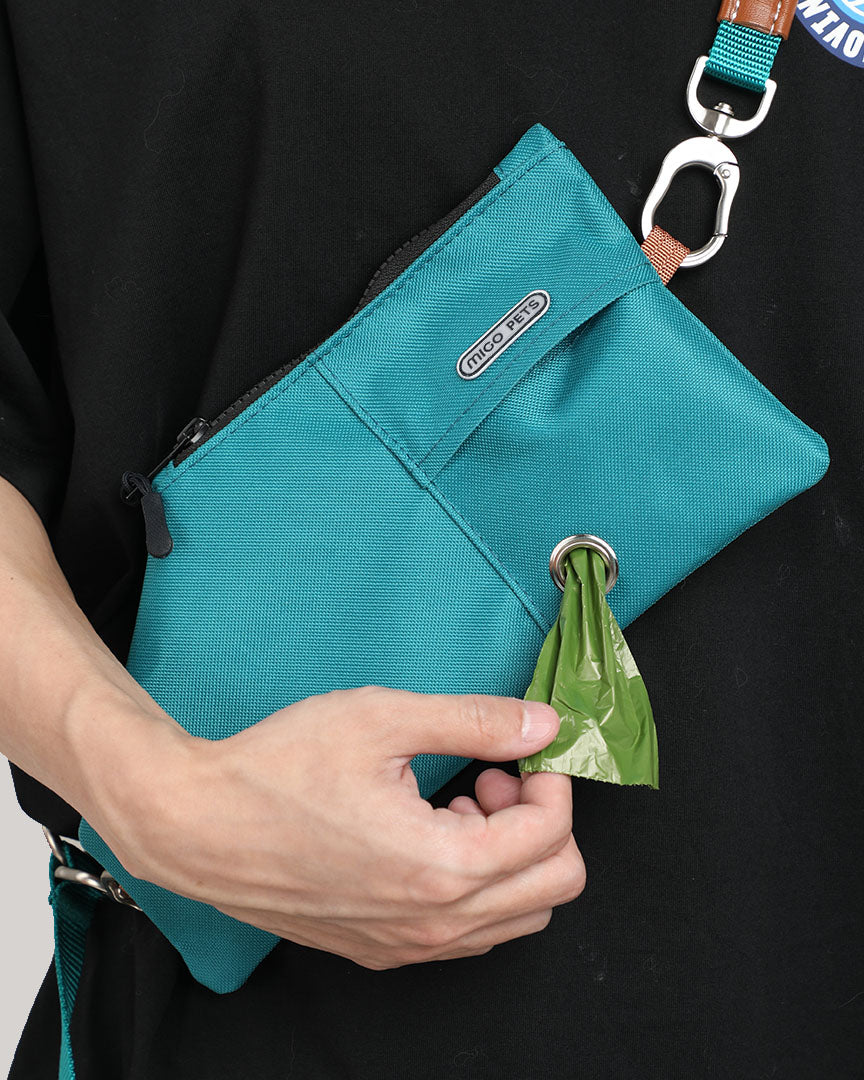 Close-up of the jade green durable crossbody travel pouch, showcasing its convenience for wearing and accessing waste bags.