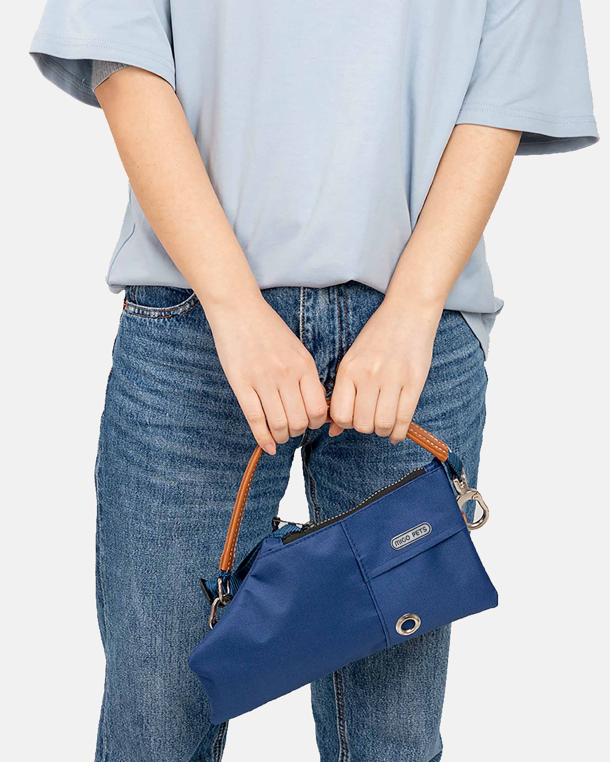 A person holding the navy blue durable crossbody travel pouch with an adjustable strap for added versatility.