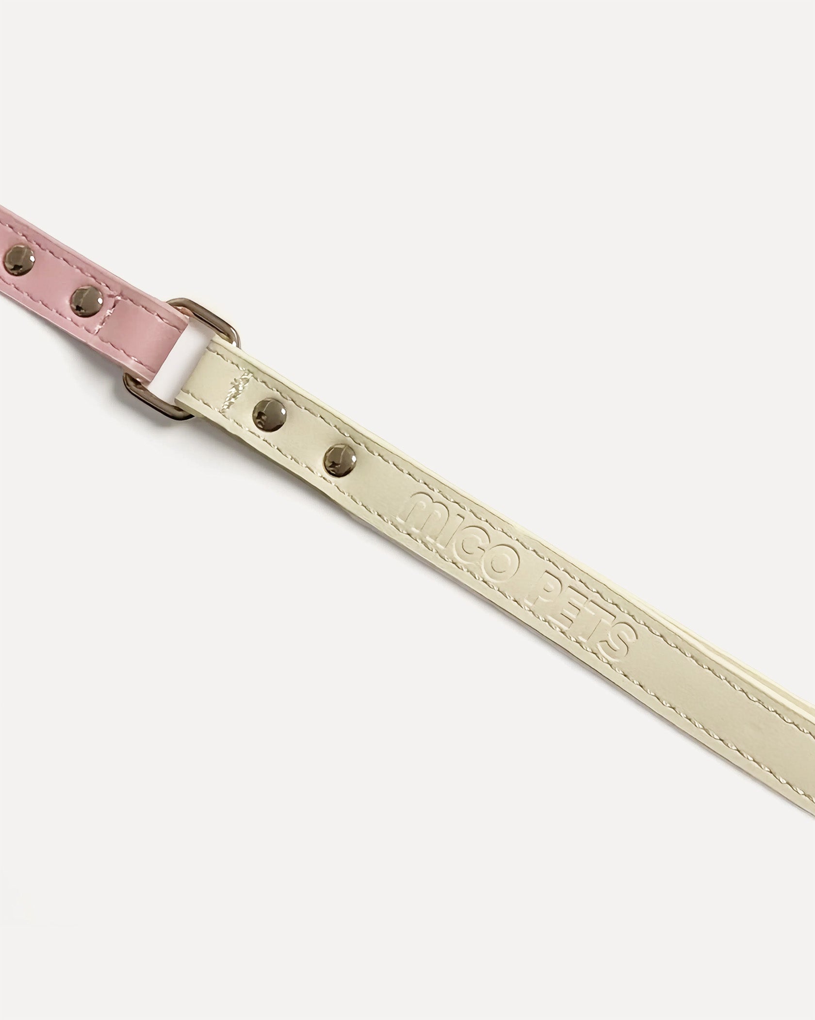 Close-up of a two-tone leather dog leash in pink with gold hardware and 'MIGO PETS' embossed on the strap.