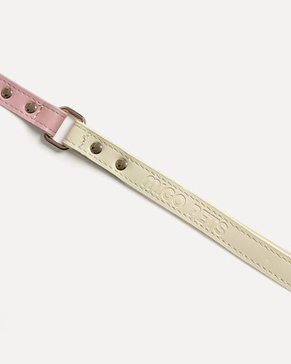 Close-up of a two-tone leather dog leash in pink with gold hardware and 'MIGO PETS' embossed on the strap.