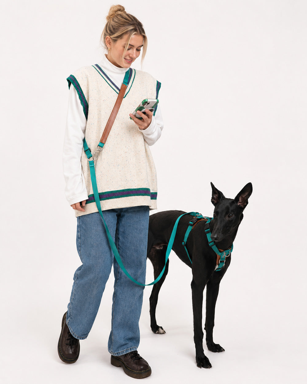 A dog wearing the jade green hands-free crossbody dog leash during a walk, allowing the owner to go hands-free, ideal for long walks or multitasking, such as checking their phone.